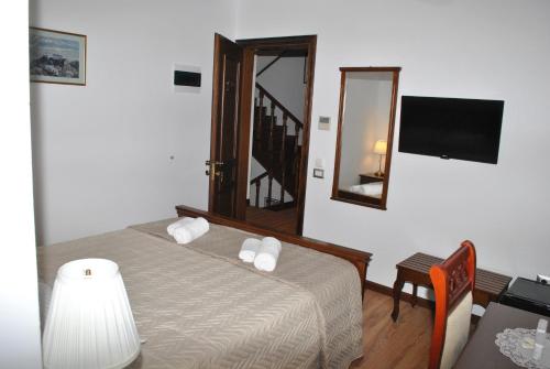 a bedroom with a bed and a mirror at Hotel Kastro in Gjirokastër