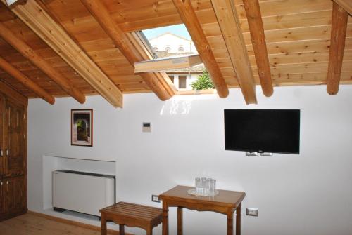 a living room with a flat screen tv and wooden ceilings at Hotel Kastro in Gjirokastër