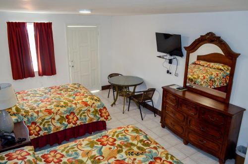 a bedroom with two beds and a mirror and a table at Fantastic Hotel in Marigot