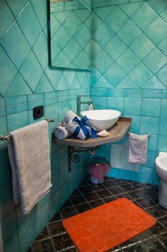 a blue tiled bathroom with a sink and a toilet at Acqua Azzurra in Alghero