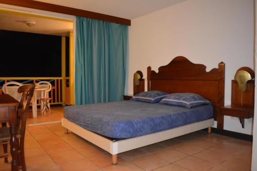 a bedroom with a bed and a dining room with a table at Appartement Mathena in Caritan