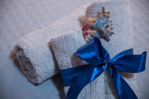 a towel with a blue ribbon and a piece of cake at Acqua Azzurra in Alghero