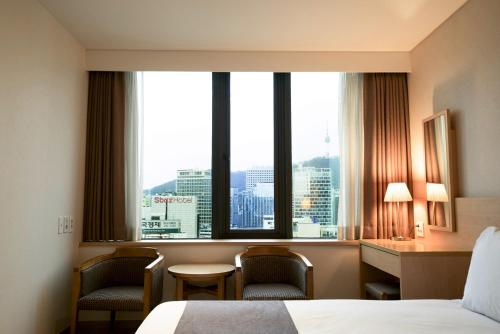 um quarto de hotel com uma cama e uma grande janela em Hotel Venue-G Seoul em Seul