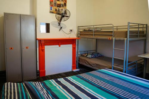 ein Zimmer mit zwei Etagenbetten und einem Schreibtisch in der Unterkunft Haus Accommodation - note - Valid passport required to check-in in Perth