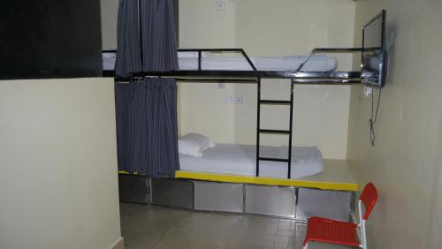 a room with two bunk beds and a red chair at Abby by the river in Ipoh