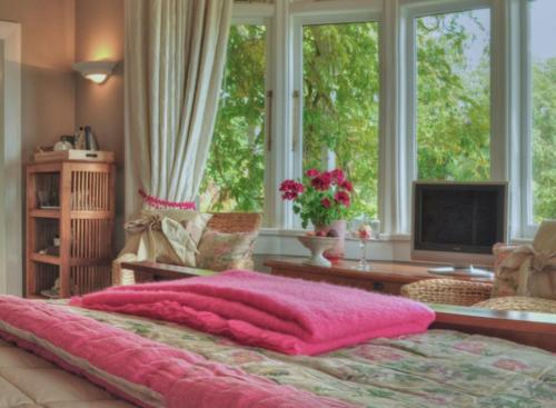 a bedroom with a pink blanket on a bed at Dyers House in Christchurch