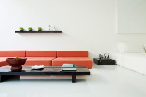 a orange couch in a living room with a coffee table at The Library - SHA Extra Plus in Chaweng