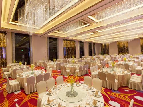 a large banquet hall with white tables and chairs at Swiss Grand Xiamen-Harbour View in Xiamen