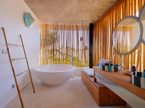 a bathroom with a large tub and a large mirror at Villa Seascape by Elite Havens in Nusa Lembongan