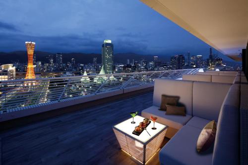 a balcony with a view of a city at night at Kobe Meriken Park Oriental Hotel in Kobe
