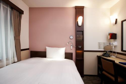 a bedroom with a white bed and a desk at Toyoko Inn Seoul Gangnam in Seoul