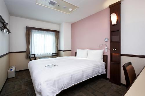 a hotel room with a white bed and a window at Toyoko Inn Seoul Gangnam in Seoul