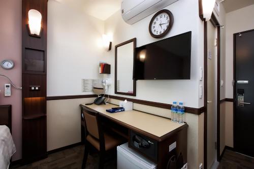 a hotel room with a desk and a clock on the wall at Toyoko Inn Seoul Gangnam in Seoul