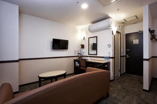 a room with a couch and a table and a tv at Toyoko Inn Seoul Gangnam in Seoul