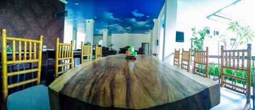 a large wooden table in a room with chairs at Mahkota Hotel in Genteng-kulon