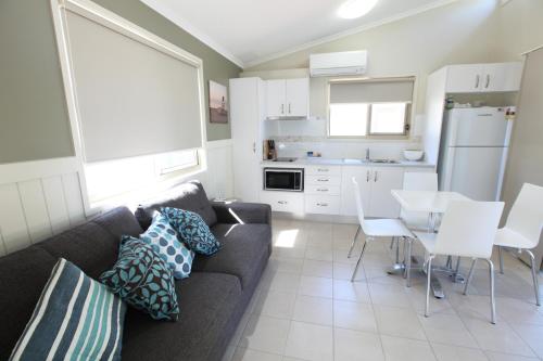 a living room with a couch and a kitchen at Halifax Holiday Park in Nelson Bay