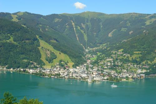 a town on the shore of a lake with mountains at Gästehaus Haffner in Zell am See