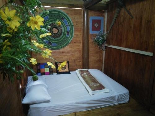 a bed in a room with yellow flowers on it at Flower hmong homestay in Bắc Hà