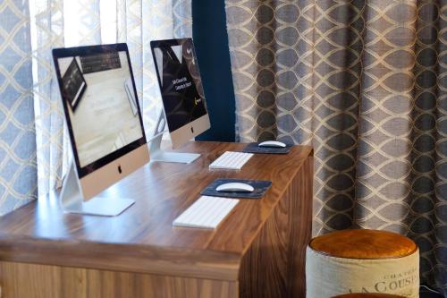 a desk with a monitor, keyboard, mouse and a coffee cup at Mantra Albury in Albury