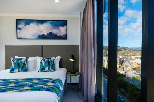 a hotel room with a bed and a large window at Mantra Albury in Albury