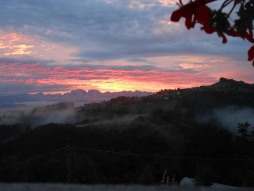 a sunset over a mountain with clouds in the sky at Agriturismo La Casa Nei Boschi in Colderù