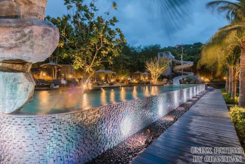 a swimming pool at the resort at night at Unixx Pattaya by Chanakan in Pattaya South