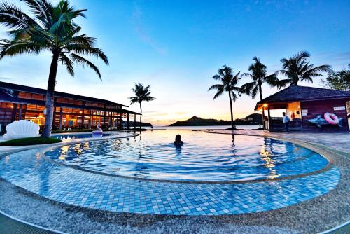 a person in a swimming pool in a resort at Island Paradise Resort Club in Koror