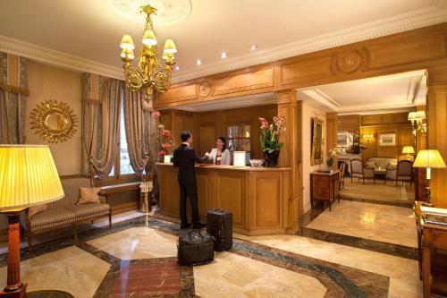 فندق مايفير باريس في باريس: رجل يقف عند كاونتر في غرفة الفندق
