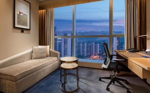 a office with a couch and a desk with a computer at Seaton International Hotel Chengdu in Chengdu