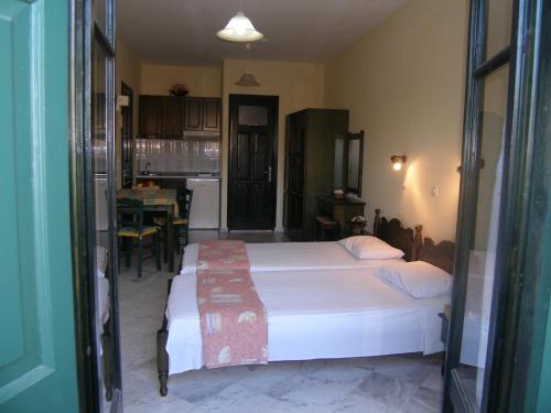 een slaapkamer met een bed en een keuken met een tafel bij Elektra Apartments & Studios in Petra