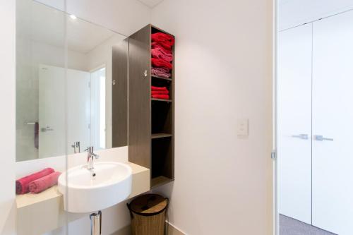 a white bathroom with a sink and a shower at Belle Vue Apartment in Fremantle