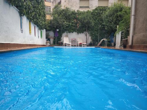 una gran piscina de agua azul en un edificio en Apartamentos Lara en Granada