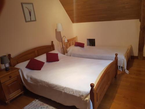 deux lits dans une chambre avec parquet dans l'établissement Champagnac, à Borrèze