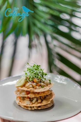 a white plate with a stack of food on a table at The Tamarind Hotel - A Boutique Heritage Stay, Anjuna - Goa in Anjuna