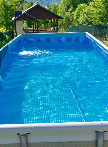 a large blue swimming pool with a gazebo at Casa David Comarnic in Comarnic