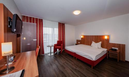 アーレンにあるHotel Grauleshofのベッドとデスクが備わるホテルルームです。