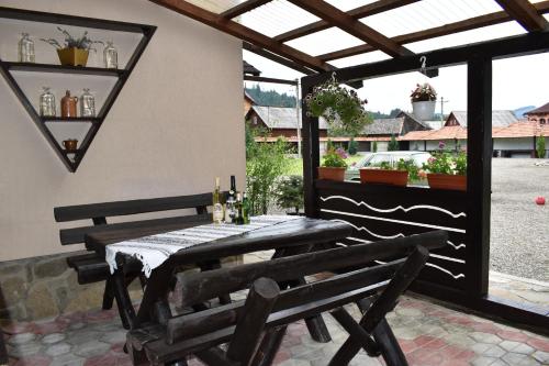 a patio with a table and chairs and a window at Clematis House in Voronet