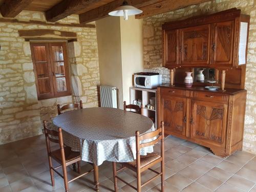 une cuisine avec une table et des chaises et un micro-ondes dans l'établissement Champagnac, à Borrèze