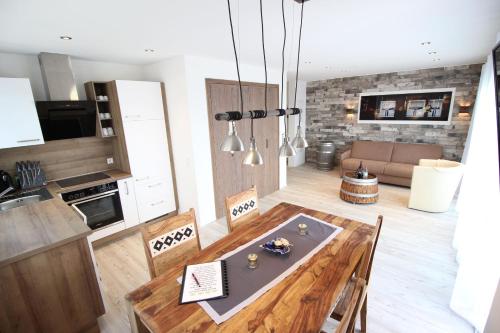eine Küche und ein Wohnzimmer mit einem Holztisch und Stühlen in der Unterkunft Reblandhof Siebenhaller in Immenstaad am Bodensee