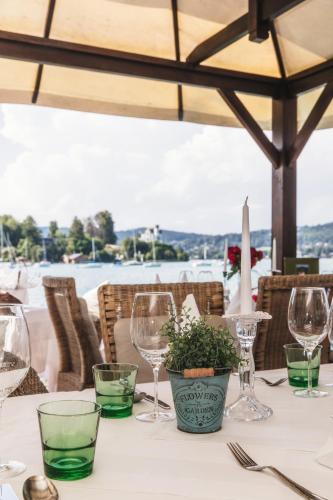 a table with wine glasses and a potted plant on it at Strandhotel Sille in Reifnitz