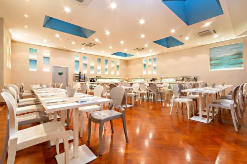 a dining room with white tables and chairs at Hotel Monte Rosa in Chiavari