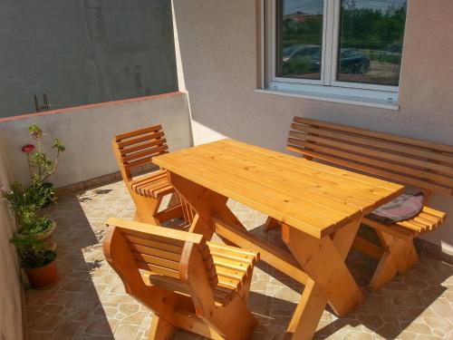 a wooden picnic table and two chairs and a window at Room in vacation home in Bar