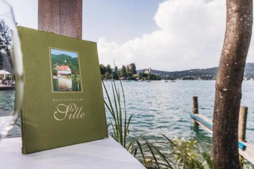a book sitting on a table next to a body of water at Strandhotel Sille in Reifnitz