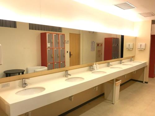 a bathroom with four sinks and a large mirror at Single inn- KAOHSIUNG LINSEN in Kaohsiung