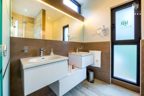 a bathroom with a sink and a mirror at Villa AltaVista - Seaview & Relax with Heated Pool & MiniGolf in Opatija