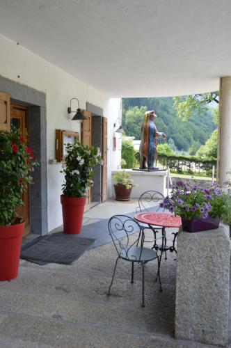 a patio with a table and chairs and a statue at Le Relais Du Mont Blanc in Magland
