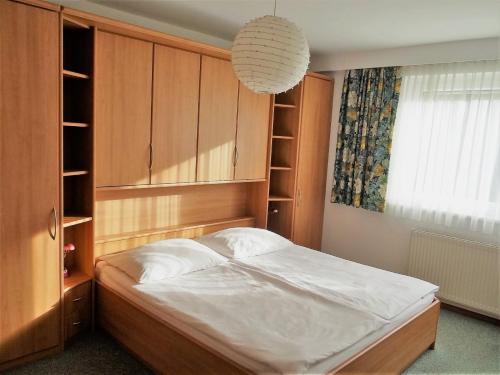 a bedroom with a bed and a chandelier at Appartements Margot in Krumpendorf am Wörthersee