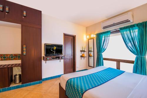 a bedroom with a bed and a tv and a window at Home@F37 Kailash Colony Metro in New Delhi