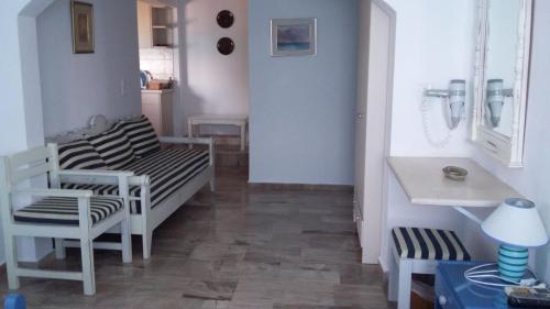 Zimmer mit 2 Stühlen, einem Bett und einem Tisch in der Unterkunft Kavos Bay Apartments Elounda in Elounda