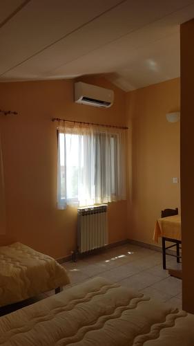 a bedroom with a bed and a window at Guest House Betiga in Barbariga